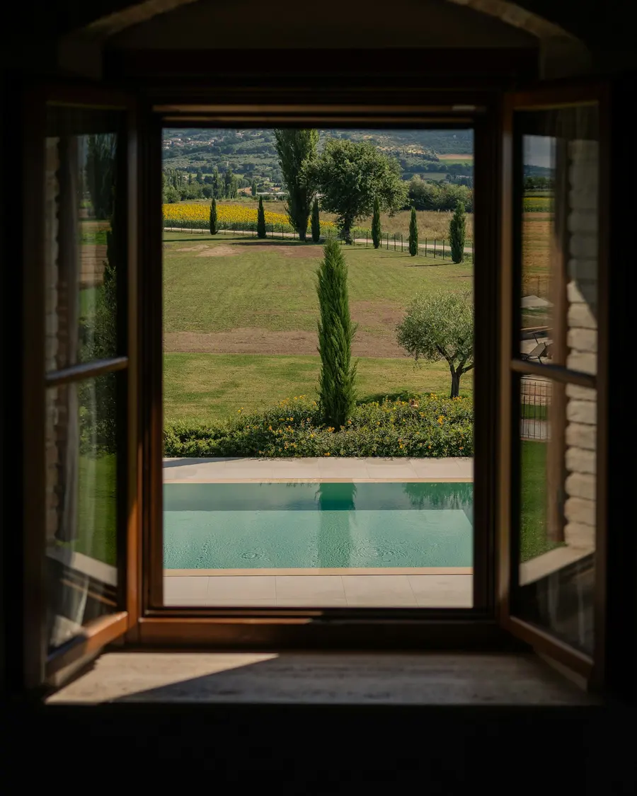 Finestra aperta su una piscina e sulla campagna toscana
